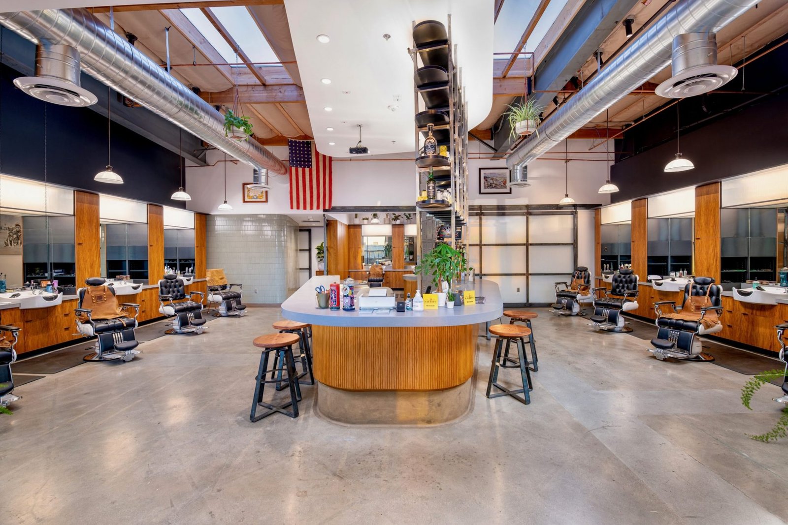 The main room at The Garrison, curved wood bar in the centre with barber chairs down both sides