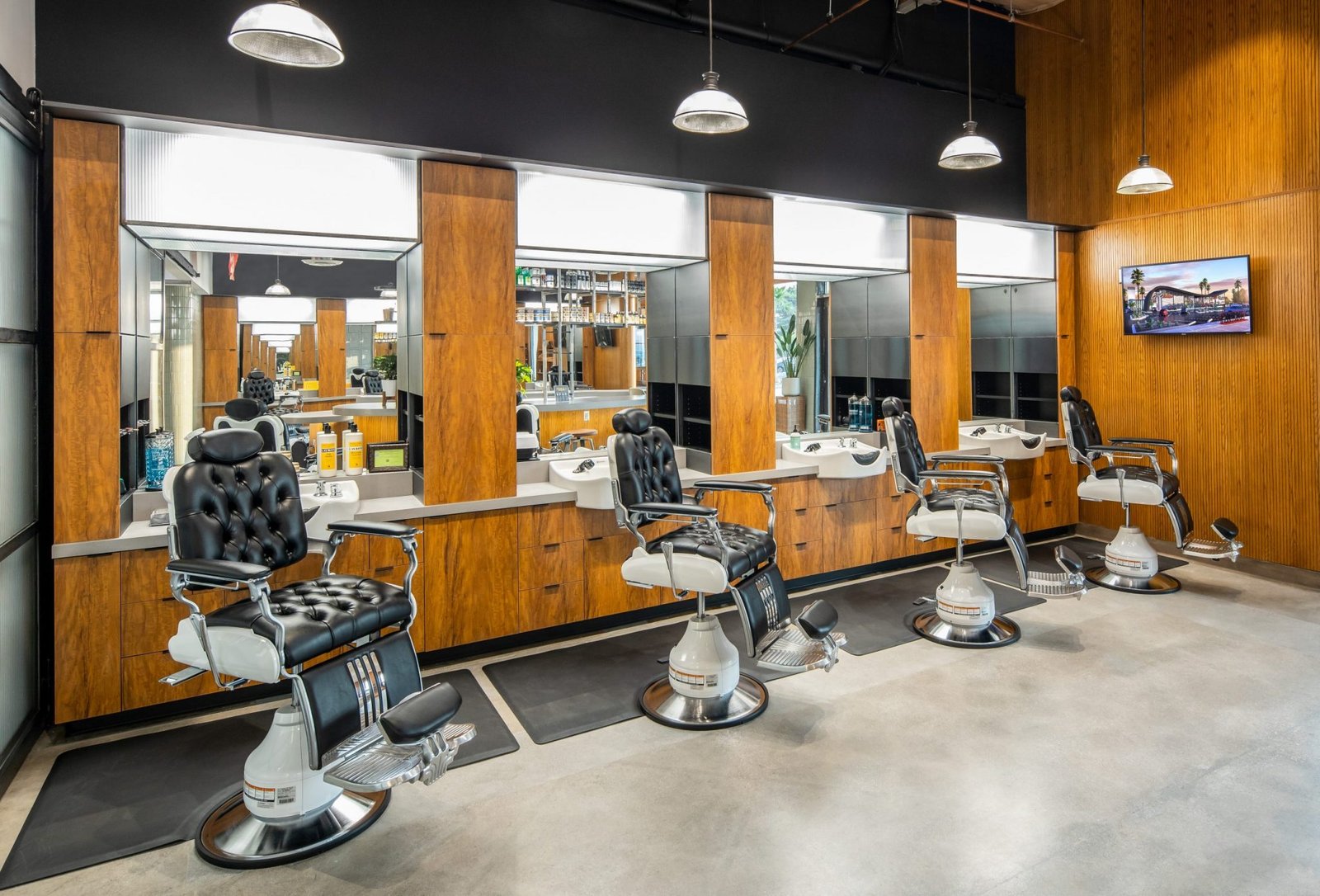 A row of classic barber chairs facing the mirrors and wood panelling
